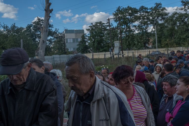 Burgers wachten op humanitaire hulp op een weg tussen Verbivka en Balaklia. Beeld Vincent Haiges