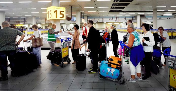 Archiefbeeld ter illustratie: reizigers die zijn aangekomen op Schiphol staan in de rij voor controle.