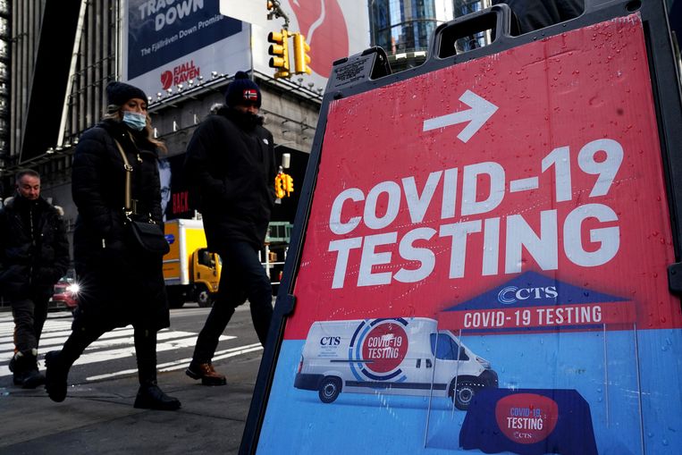 Mensen lopen langs een reclamebord voor coronatests in New York City, de Verenigde Staten. Beeld REUTERS