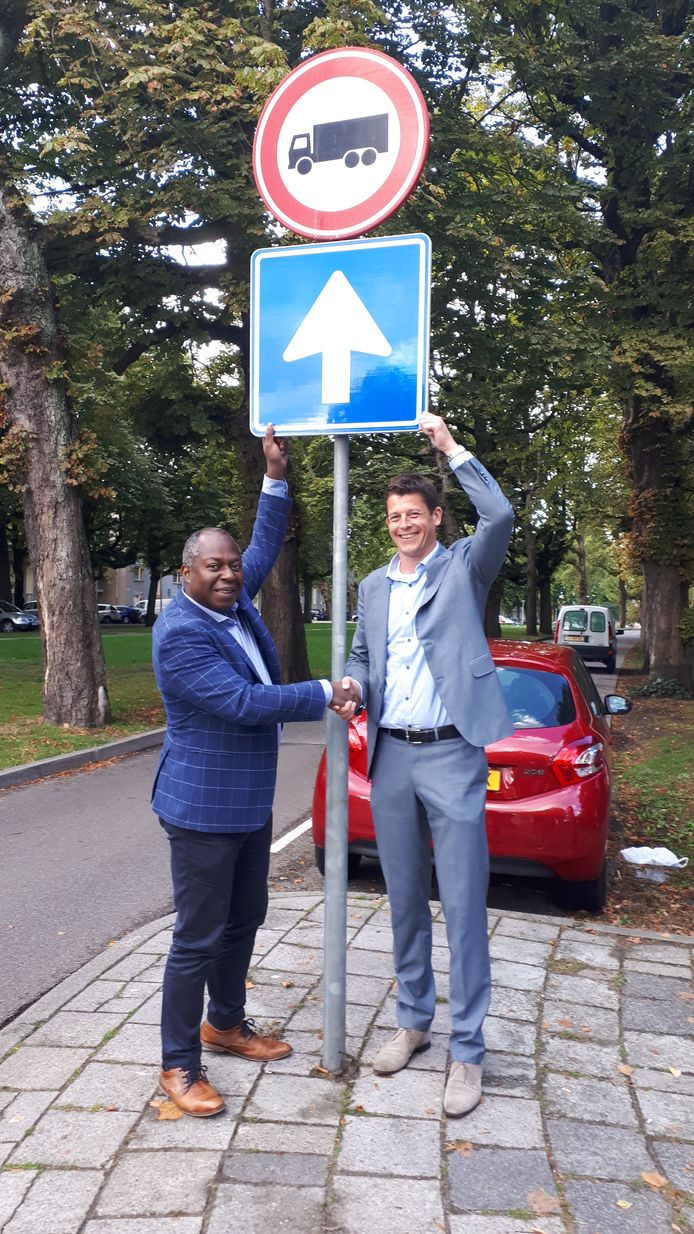 Wethouder Andrew Harijgens (l) en Rolf Groot  van het bedrijf NPSP feliciteren elkaar met het duruzame verkeersbord.