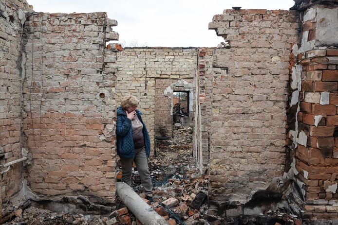 Een vrouw huilt als ze in haar verwoeste huis stapt in het Oekraïense Ozera.