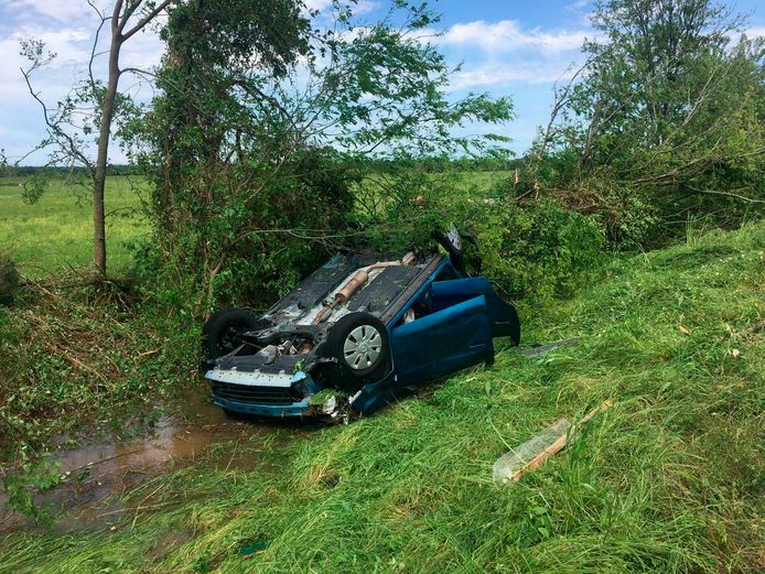 Een auto ligt op z'n kop in de sloot in Franklin, Texas, na de doortocht van wat mogelijk een tornado was.