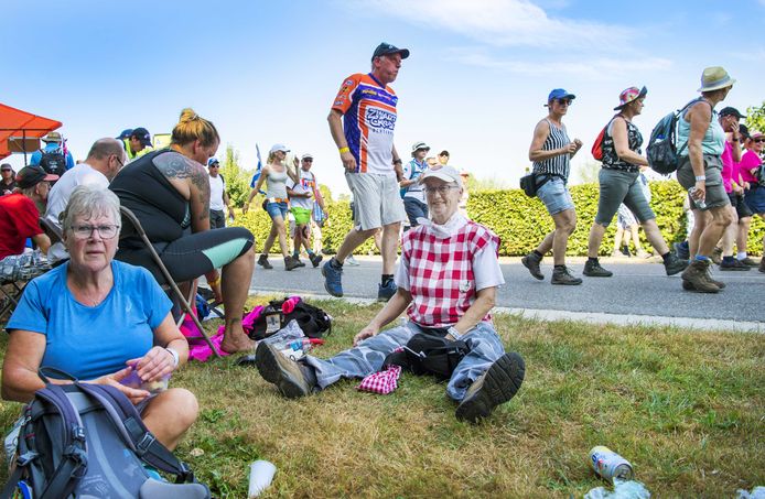 Wandelaars nemen rust op de eerste wandeldag van de 102e editie van de Nijmeegse Vierdaagse.