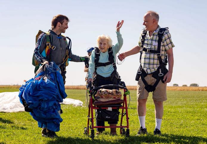 Dorothy Hoffner (104) waves to a crowd of people after her jump.  Next to her are her nurse and dear friend Joe Conant (right) and skydiver Derek Baxter (left).