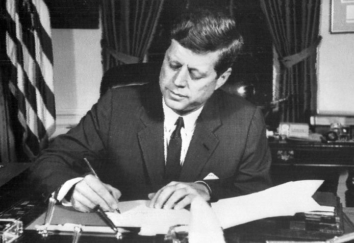 President John Fitzgerald Kennedy tekent het bevel van een marineblokkade van Cuba.