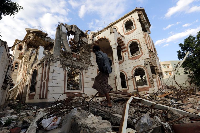 Een Jemeniet loopt door de puinhopen van een verwoest gebouw in Sanaa, na vermoedelijk een Saudisch bombardement. Beeld EPA
