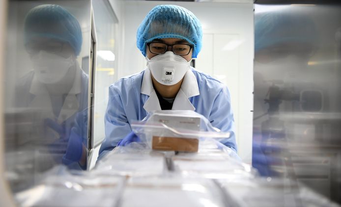 Chinese onderzoekers verpakken testmateriaal om het virus op te sporen.