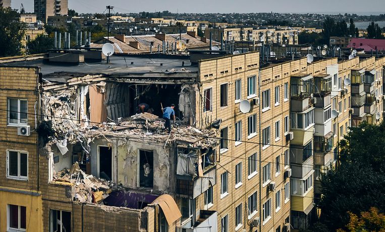 Een man zoekt naar persoonlijke bezittingen in een appartement dat is vernietigd door een Russisch bombardement in het Oekraïense Nikopol, in augustus. Beeld AP