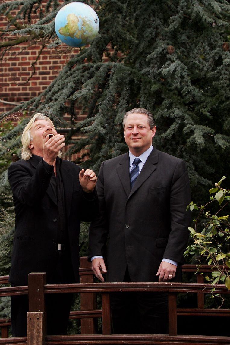 Richard Branson gooit een globe de lucht in bij de presentatie van de Virgin Earth Challenge in Londen, februari 2007, met naast hem Al Gore. Beeld Getty Images