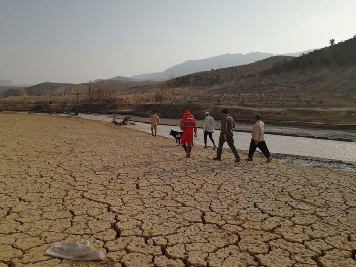 Reddingswerkers zoeken naar vermiste mensen in de buurt van een rivieroever na de overstromingen in het zuiden van Iran.