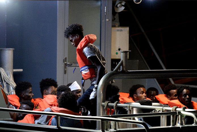 Migranten worden met een patrouillebootje aan land gebracht vanaf het reddingsschip Alan Kurdi.