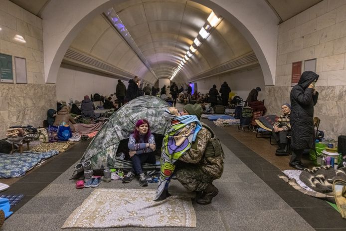 Seorang tentara Ukraina memeluk putranya yang bersembunyi bersama istrinya di metro Kyiv.