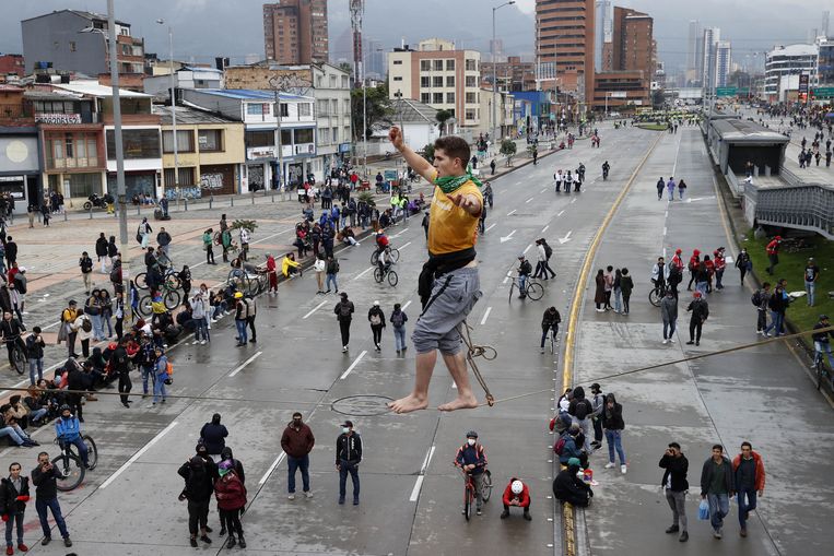 Een koorddanser treedt op in Bogotá, tijdens de herdenking van de protesten tegen de belastinghervormingen in Colombia, een jaar geleden. Bij de protesten, waarbij tienduizenden Colombianen de straat opgingen, kwamen 83 mensen om het leven.  Beeld ANP / EPA