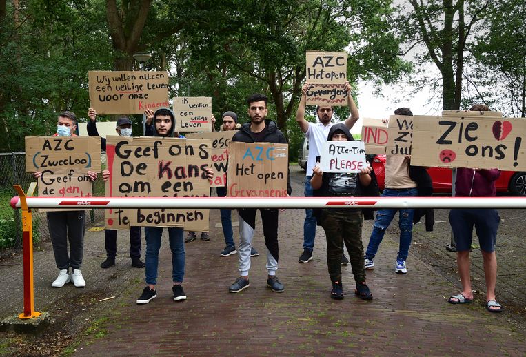 Voor de poort van het asielzoekerscentrum in Zweeloo protesteren asielzoekers tegen de ongelijke behandeling van asielaanvragen.  Beeld Marcel van den Bergh / de Volkskrant