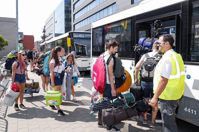 Festivalgangers nemen de festivalbus aan het station van Leuven.