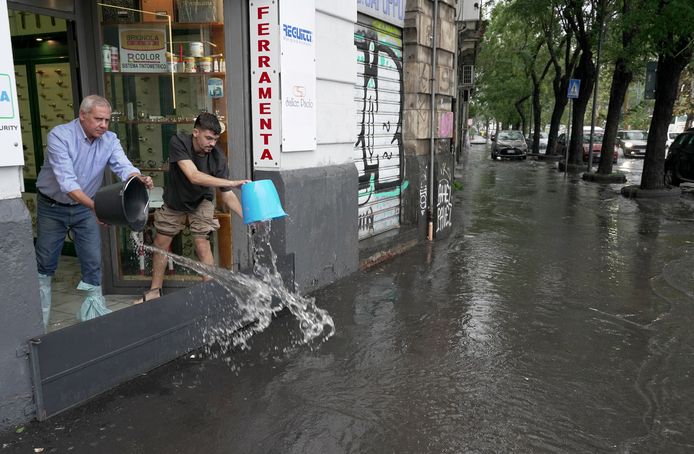 26 oktober 2021: Mensen proberen het water uit hun winkel te krijgen in de op één na grootste stad van Sicilië, Catania.