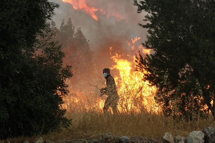 Een vrijwilliger loopt voorbij de vlammen in Oren, nabij Milas, in de Turkse provincie Mugla.