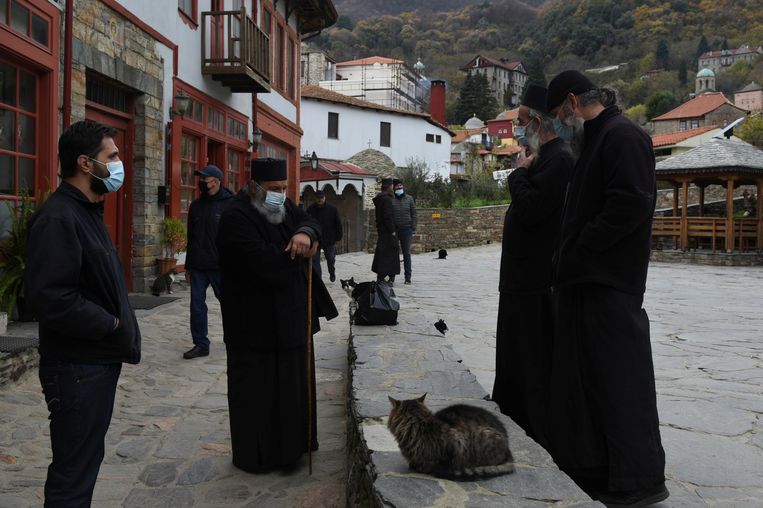 Enkele oudere Grieks-orthodoxe geestelijken op de berg Athos, een orthodox spiritueel centrum in het noorden van Griekenland, spreken elkaar nadat zij zijn gevaccineerd tegen het coronavirus. Beeld Reuters