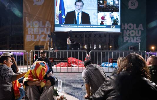 Mensen luisteren naar een toespraak van de Spaanse premier Mariano Rajoy op Plaza Catalunya in Barcelona terwijl ze wachten op de resultaten van het referendum.