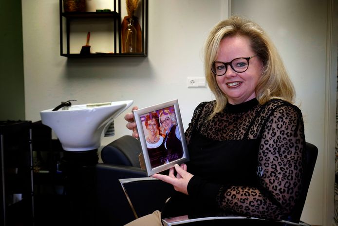 Patty Weterings met een foto van haar moeder Adje en zijzelf, samen op een kappersbeurs. De foto staat in de kapsalon die Patty na haar moeders overlijden voortzet.