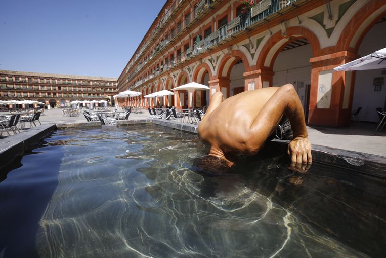 Tijdens de hittegolf in de zomer van 2022 koelt een man zijn hoofd in een fontein in de Zuid-Spaanse stad Cordoba. Beeld ANP / EPA