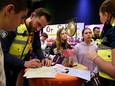De twee 14-jarige leerlingen van het Kalsbeek College in Woerden (links Bobby Jordan en Maaike) laten zich op het Beroepenfeest door handhavers informeren over hun vak.