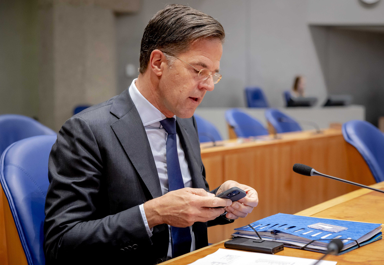Premier Mark Rutte - met smartphone -  in de Tweede Kamer tijdens het debat over de sms-berichten.