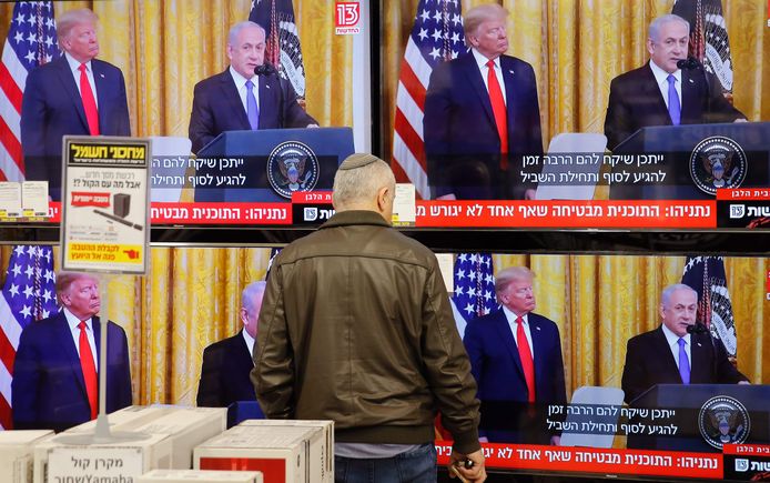 Een man bekijkt de persconferentie in Israël.