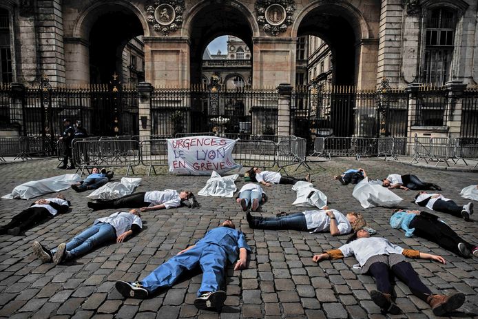Medewerkers van de Eerste Hulp-posten van de ziekenhuizen in het Franse Lyon houden een 'dood-lig'-actie voor het stadhuis in die plaats. Ze protesteren hiermee tegen hun slechte arbeidsomstandigheden. Foto Jeff Pachoud