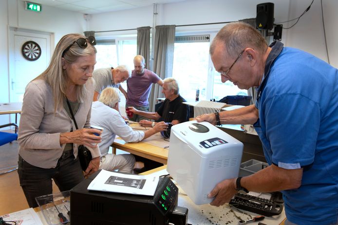 Vrijwilliger Rob Kranenburg helpt Wil Kieboom met haar kapotte broodbakmachine in het Repair Café Vianen.