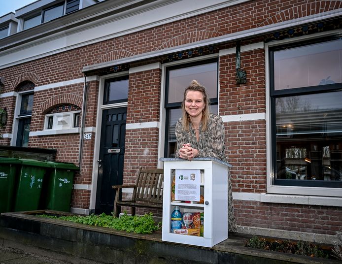 Marijn Iwema bij haar buurtkastje met boodschappen in haar voortuin.