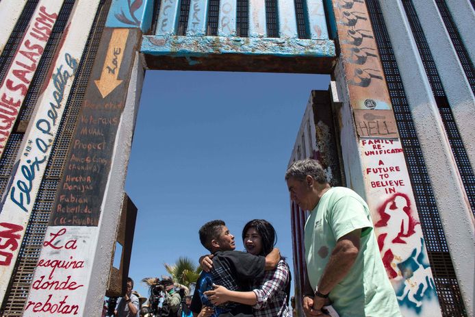 De uitgezette migrante Sonia Lopez en haar dochter Lisbeth Borja omhelzen elkaar wanneer de grens kort opengaat voor het evenement 'Opening the Door of Hope', waarbij zes door de grens gescheiden families elkaar kort konden omhelzen.