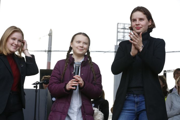 Activisten Kyra Gantois, Greta Thunberg en Anuna De Wever op het podium na de zevende klimaatmars die aan Brussel-Zuid haar eindpunt bereikte.