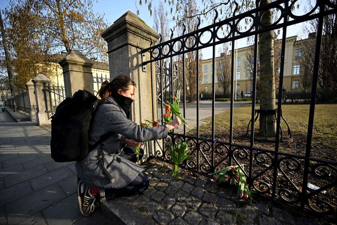 Vrouw legt bloemen neer voor de school waar de moorden gebeurde.