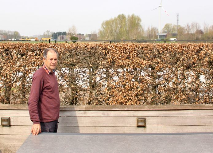 Joseph Boone in zijn achtertuin. Achter de haag zou de nieuwe industriezone gekomen zijn.