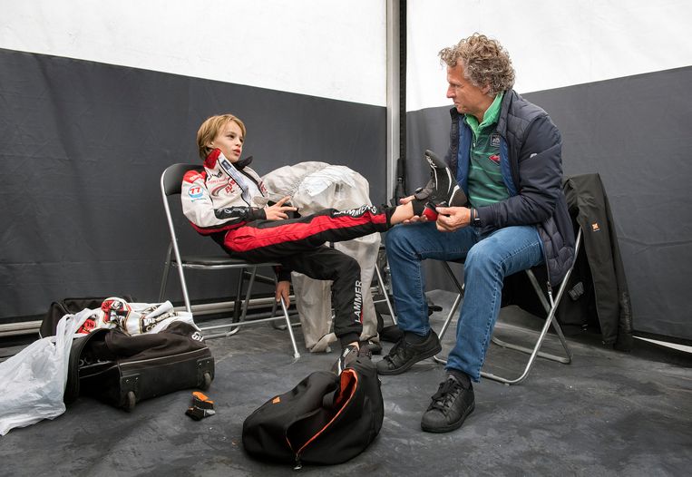 René wordt voor de start van de race door vader Jan geholpen met het aantrekken van zijn raceschoenen. Beeld Klaas Jan van der Weij / de Volkskrant