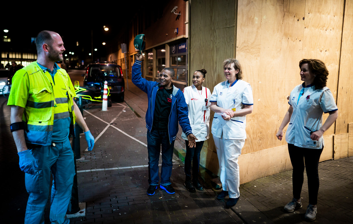 Een man neemt zijn pet af voor een ambulancebroeder die aankomt bij de eerste hulp. Beeld Freek van den Bergh / de Volkskrant