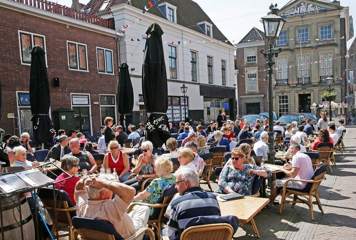 Toeristen genieten van een drankje op het terras in het Brielle.