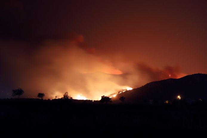 Des flammes illuminent le ciel nocturne et la fumée après que des feux de forêt aient atteint la centrale électrique de Kemerkoy, une centrale électrique alimentée au charbon, à Milas, dans le sud-ouest de la Turquie, tard le mercredi 4 août 2021.
