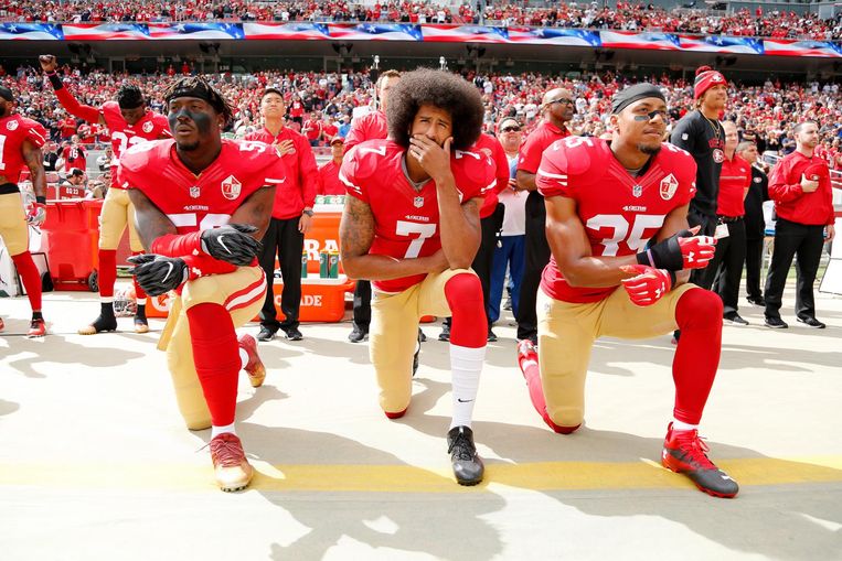 Colin Kaepernick (midden) protesteerde in 2016 al tegen racisme door tijdens het volkslied op een knie te gaan zitten. Beeld epa