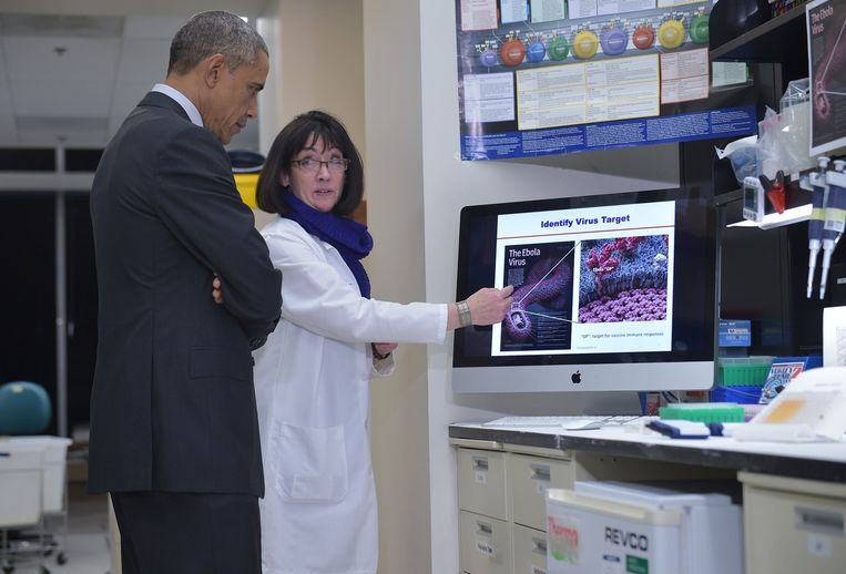Amerikaanse president Barack Obama luistert naar een onderzoeker die vertelt over vaccinatie tegen ebola. Beeld anp