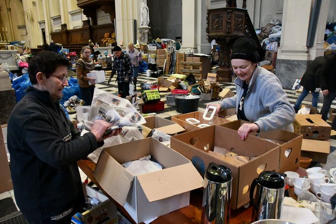 In de kerk van het Grootseminarie in Brugge zijn enkele tientallen vrijwilligers aan de slag om alle ingezamelde hulpgoederen te sorteren, om eind januari vijf vrachtwagens vol bruikbare spullen naar Trooz te kunnen sturen.