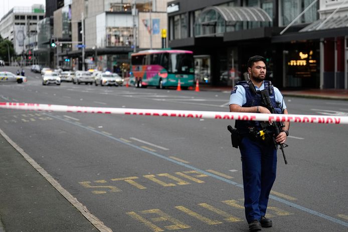 Een gewapende politieagent houdt de wacht bij een afgezette straat in het centrum van Auckland.