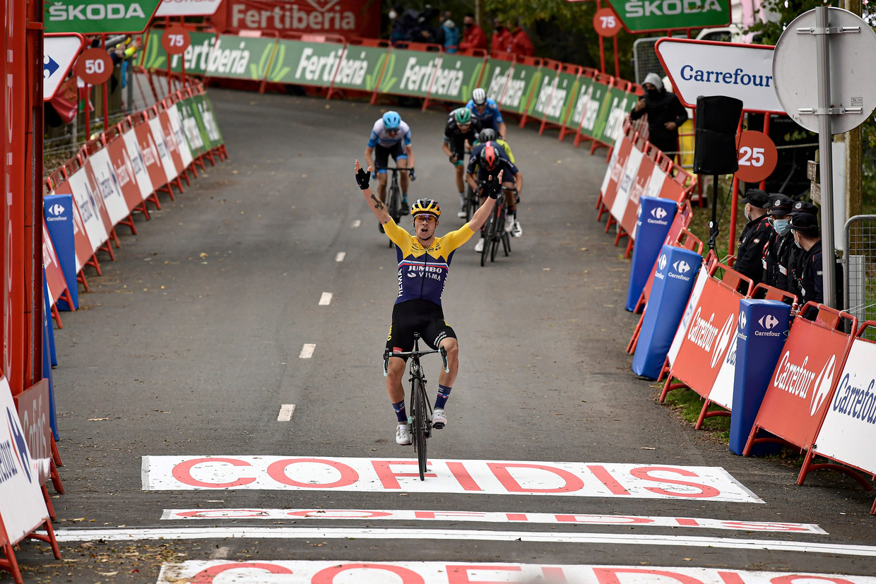 Terwijl zijn medevluchters sprinten om de de tweede plaats, komt Primoz Roglic juichend over de finish van de eerste etappe van de Vuelta. Beeld AP