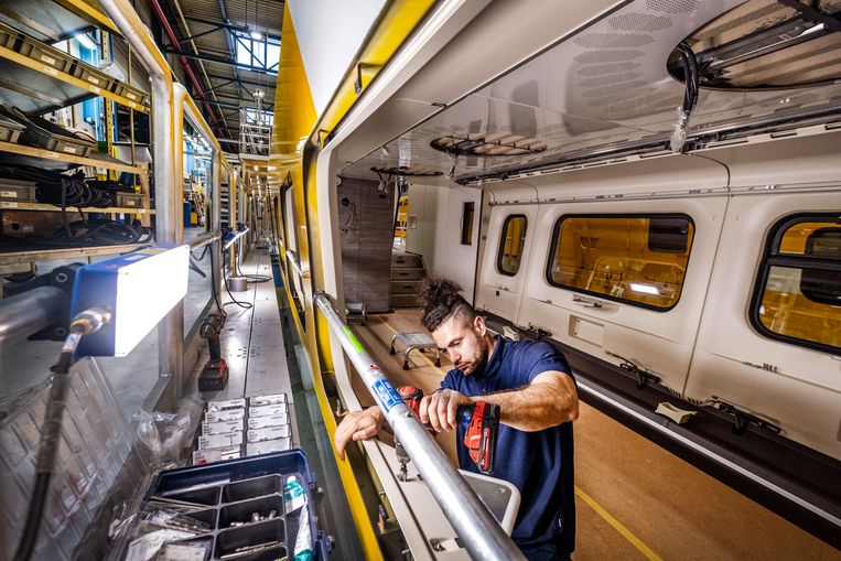 Statushouder Mohammad bezig met de bedrading van het treinstel van een Intercity. Tot voor kort had hij amper een schroevendraaier vastgehouden. Beeld Raymond Rutting / de Volkskrant