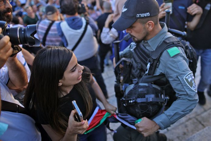 Een Israëlische agent probeert een Palestijnse vlag van een vrouw af te nemen tijdens de vlaggenmars.