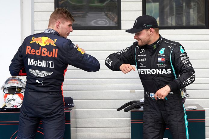 Max Verstappen en Valterri Botas geven elkaar een elleboog.