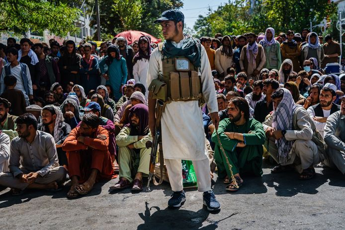 Honderden Afghanen wachten geduldig hun beurt af om geld af te halen van een bank.