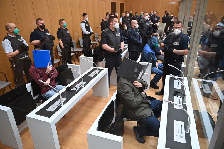 In een rechtbank in Stuttgart houden verdachten hun gezicht verborgen voor de fotograaf. Beeld EPA