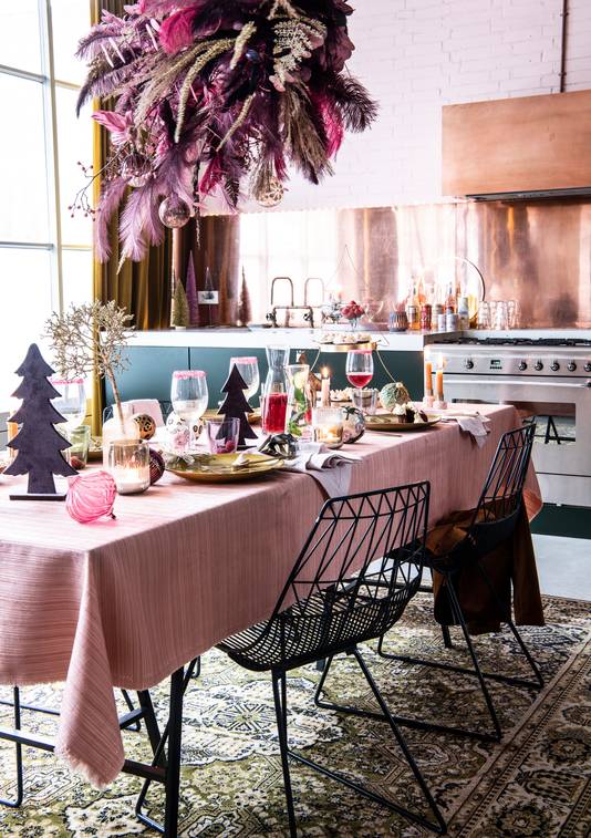 Kersttafel met lichte kleuren en pluimen.